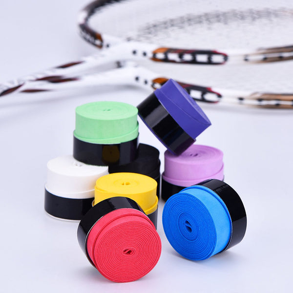 Frosted dry grip tape for sports equipment in various colors, stacked, with tennis rackets in the background.